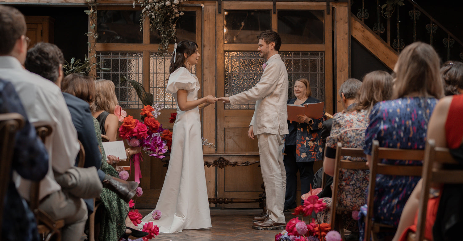 Wedding ceremony with a couple shaking hands in front of an audience.