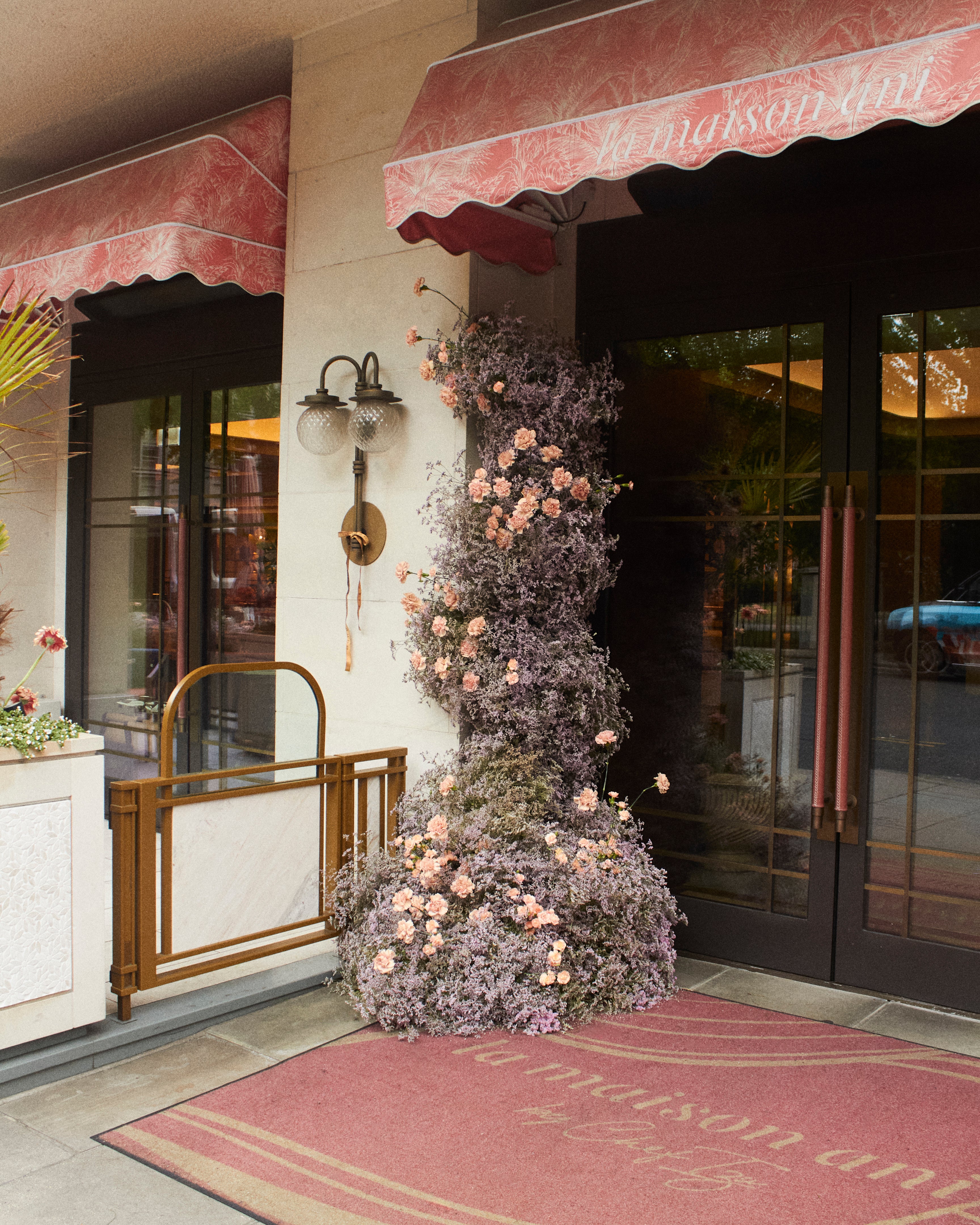 Decorative floral arrangement outside a building with 'L'Antinori' branding.