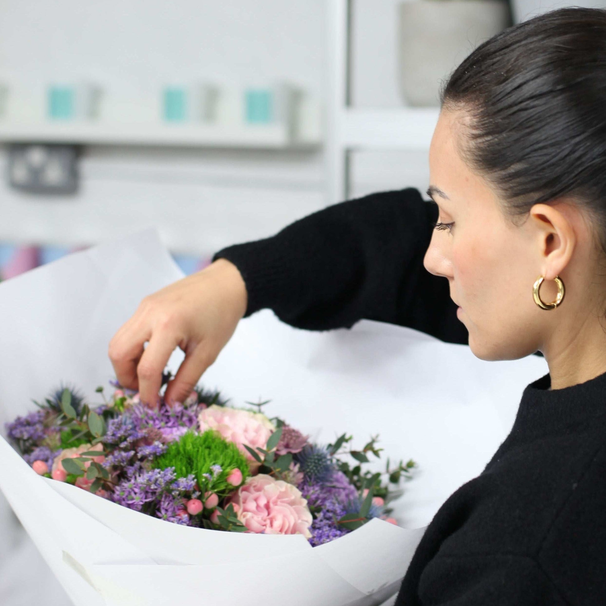Woman arranging flowers in a store setting